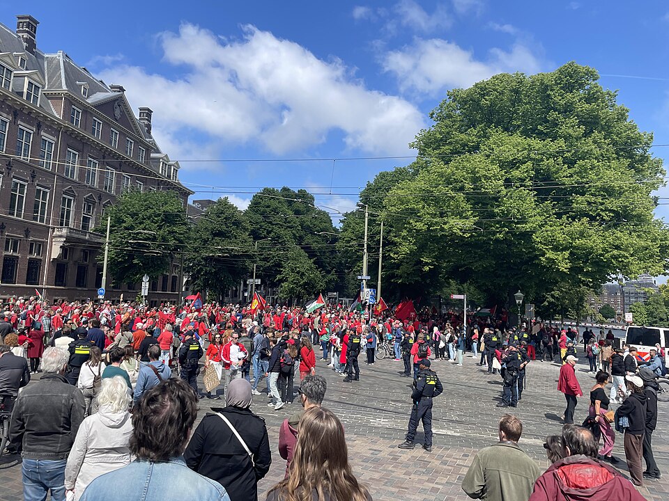 Demonstranten met spandoeken en vlaggen lopen door de straten van Den Haag. Foto: Diloba via Wikimedia Commons (CC BY 4.0)